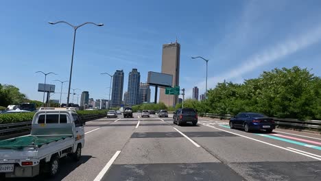 Vehicles-Driving-Through-Olympic-daero-Highway-Passing-By-63-Building-Tower-and-High-rise-Structures-In-Seoul,-South-Korea