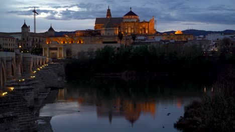 Wunderschöne-Beleuchtung-Der-Mezquita-Kirche-In-Cordoba,-Spanien-Mit-Flussreflexionen