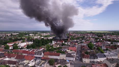 Close-aerial-shot-of-black-smoking-burning-building-in-KÃ¶then-Germany