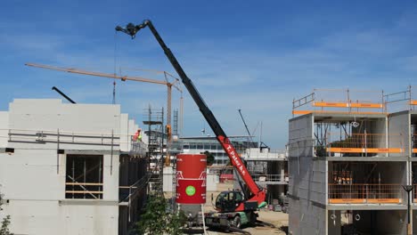 Time-lapse-of-day-in-the-life-of-a-crane-on-a-construction-site-dispersing-building-material-where-needed-at-PUUR12-urban-development-project-against-a-blue-sky