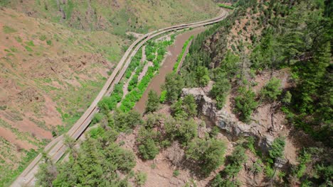Drone-Footage-Flying-Over-Steep-Canyon-Cliff-Covered-In-Lush-Alpine-Trees-And-Foliage-Near-Colorado-River-Glenwood-Canyon-Colorado-USA