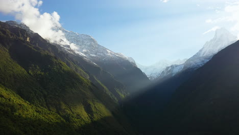 Epic-drone-shot-of-the-sun-beams-shining-through-the-Annapurna-mountains,-Nepal
