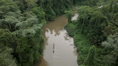 Aerial-flyover-people-in-boat-cruising-on-Amazon-River-in-Jungle-during-daytime
