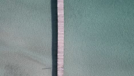 Straight-Down-view-of-Wooden-Pier-Going-into-Turquoise-Blue-Sea-Water-in-Mallorca