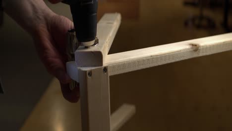 Holes-drilled-into-clamped-pine-lumber-for-DIY-project,-narrow-focus