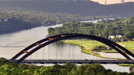 Aerial-sweep-of-360-Pennybacker-bridge-and-Austin-Country-club-overlooking-Lake-Austin-with-zoomed-in-drone-during-summer-sunrise-morning-in-2022