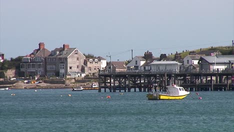 Un-Barco-Blanco-Y-Amarillo-Amarrado-Frente-A-Un-Muelle-Victoriano-En-La-Ciudad-De-Swanage,-En-Dorset,-Reino-Unido.