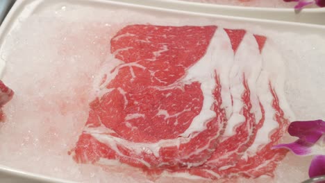panning-close-up-view-of-raw-wagyu-beef-sliced-ready-to-make-hotpot-shabu