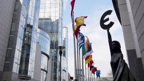 Estatua-De-Europa-Sosteniendo-Un-Símbolo-Del-Euro-Junto-Al-Edificio-Del-Parlamento-Europeo