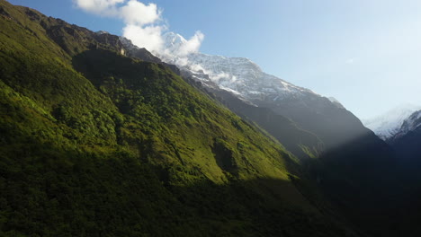 Disparo-De-Drone-Giratorio-Del-Sol-Brillando-En-La-Cara-De-Las-Montañas-Annapurna,-Nepal