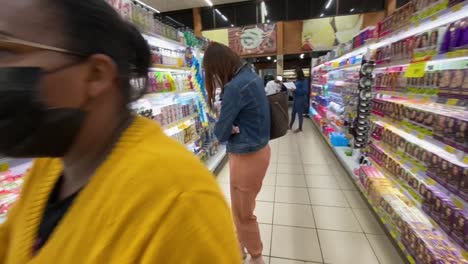 images-of-a-lady-and-some-people-in-the-corridor-of-a-large-supermarket-among-the-products