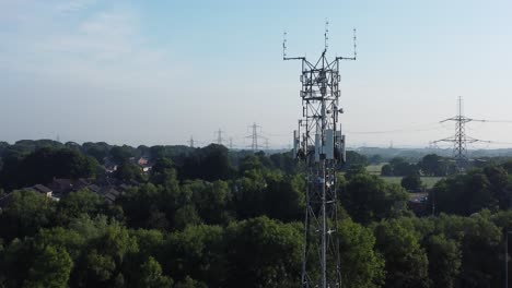 5G-broadcasting-tower-antenna-in-British-countryside-landscape-background-slow-aerial-dolly-right-view