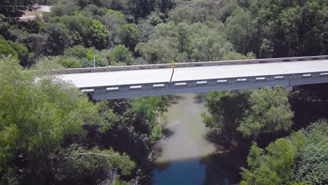 Rauchschwalben-Fliegen-Um-Die-Kamera-Herum,-Während-Die-Drohne-Auf-Eine-Brücke-über-Den-San-Antonio-River-In-Der-Kleinstadt-Elmendorf-Zufliegt