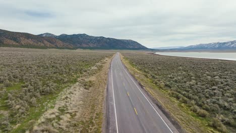 AERIAL---Truck-on-highway-next-to-Scipio-Lake,-Utah,-wide-shot-reverse