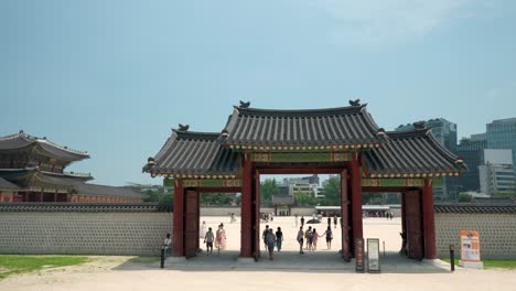 Reisende-Ziehen-An-Einem-Sonnigen-Tag-Durch-Das-Yongseongmun-Tor-Des-Gyeongbokgung-Palastes-Ein-Und-Aus.-Vorderansicht