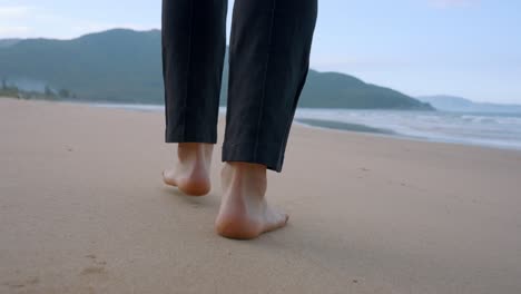 Nahaufnahme-Der-Füße-Eines-Mannes,-Der-Bei-Herrlichem-Sonnenschein-Am-Strand-Spaziert