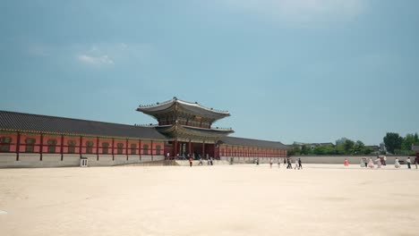 Unrecognizable-tourists-wearing-Korean-traditional-dress-Hanbok-enter-Heungnyemun-Gate-of-Gyeongbokgung-Palace---wide-angle