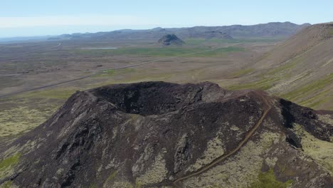 Aerial-flyover-volcano-crater-and-scenic-landscape-of-Iceland-Island-during-bright-sunlight-and-blue-sky