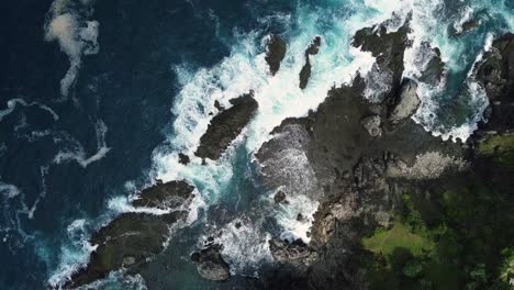 top-down-drone-shot-of-waves-beating-the-rocky-shores-of-siung-beach-in-yogyakarta-in-indonesia