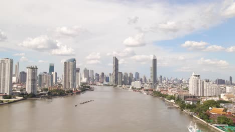 Vista-Aérea-Del-Río-Chao-Phraya-Con-Fondo-De-Rascacielos-De-Bangkok-En-Un-Día-Nublado,-Tailandia