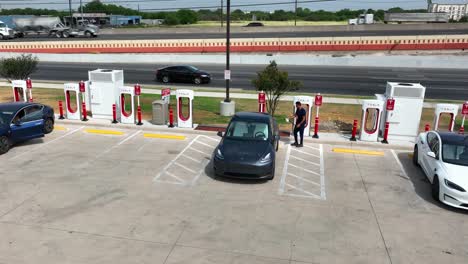 Person-uses-Tesla-charger-to-recharge-electric-vehicle-battery