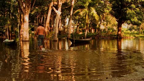 Un-Pescador-Indígena-Del-Río-Amazonas-Vadea-Para-Comprobar-Su-Barco-Al-Atardecer.