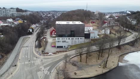 Kuben-museum-and-archives-in-Arendal-Norway---Rotating-aerial-view-of-exterior-with-city-background