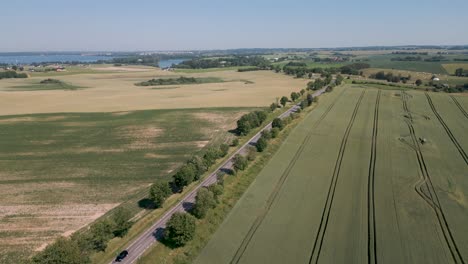 A-romantic-country-road-with-trees-on-the-left-and-right-winds-through-the-Mazury-Region-in-Poland---A-romantic-camera-flight-from-bird-perspective-shows-the-amazing-landscape