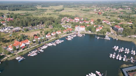 Mikolajki,-Poland---Aerial-bird-view-flight-flyover-the-harbor-of-the-touristic-city-in-Warmian-Masurian-with-tiny-passenger-ships-and-expensive-yachts-on-a-beautiful-calm-lake-in-summer