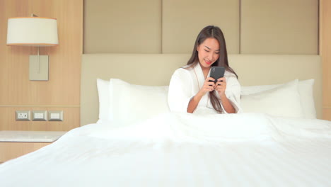 Pretty-Asian-Adult-Woman-Playing-and-Winning-Game-on-Smartphone-after-Bath