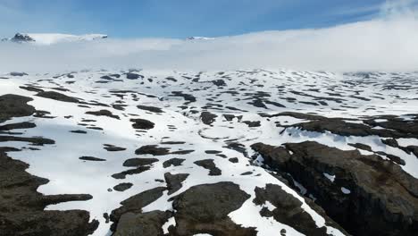 Vuelo-Aéreo-Sobre-El-Paisaje-Montañoso-Cubierto-De-Nieve-En-Noruega