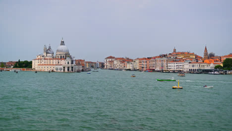 Boats-Sailing-At-Venetian-Lagoon-With-Santa-Maria-della-Salute-Basilica-In-Venice,-Italy