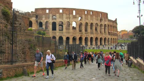 Panning-across-the-remains-of-the-roman-empire-with-ancient-and-historic-colosseum-in-Rome,-Italy