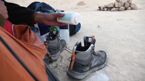 Hand-From-Sleeping-Tent-Applying-Talcum-Powder-To-Hiking-Boots