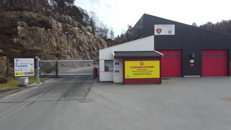 Approaching-coronavirus-poster-and-closed-gate-outside-opening-hours-of-GE-Healthcare-in-Lindesnes-Norway