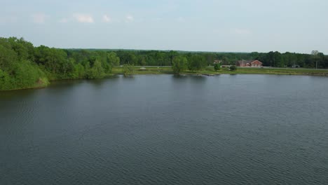 A-drone-shot-of-a-beautiful-lake-in-summer-time-with-it's-green-surroundings