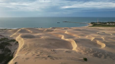 beautiful-take-with-drone-leaving-the-middle-of-the-dunes-towards-the-sea,-northeast-of-brazil,-magic-light-of-the-sunset