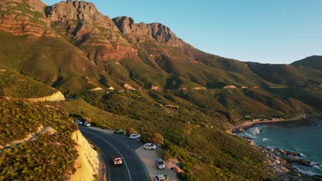 Malerische-Küstenfahrt-Entlang-Der-Chapmans-Peak-Road-In-Kapstadt-Bei-Sonnenuntergang,-Luftaufnahmen