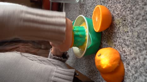 Vertical-Shot-Of-A-Woman-Squeezing-Fresh-Orange-Fruit-Juice