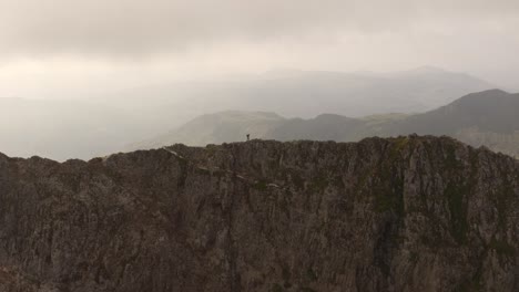 Man-Hiking-on-Mountain-Ridge-during-Sunrise-in-Wales,-United-Kingdom