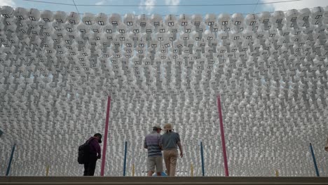 Bongeunsa-Temple---Middle-aged-couple-walking-up-the-stairs-under-rows-of-classic-white-round-paper-lanterns-with-blessing-cards-hanging-on-line-for-decorative-in-celebrate-event