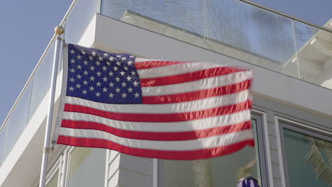 Eine-Nahaufnahme-Einer-Amerikanischen-Flagge,-Die-Vor-Einem-Haus-Weht