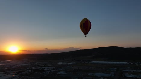 Wide-shot-of-a-hot-air-balloon-soaring-through-the-golden-sky