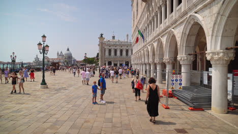 Gente-Caminando-Frente-Al-Palacio-Ducal-Hacia-La-Colonna-Di-San-Marco-Y-La-Colonna-Di-San-Todaro-En-Venecia,-Italia