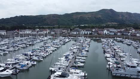 Aerial-view-Wealthy-luxury-yachts-and-fishing-boats-moored-in-quaint-Conwy-town-marina