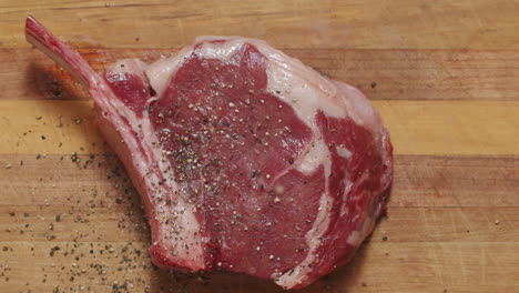 Close-Up-Cracking-Pepper-Seasoning-On-Beef-Steak-Fillet-On-Wooden-Board-In-Slow-Motion,-4K