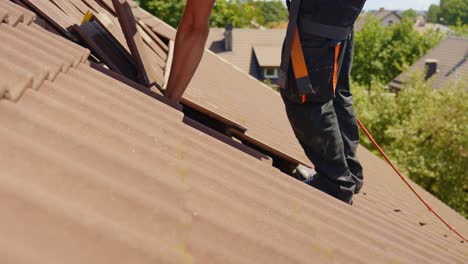 Working-at-height-on-house-rooftop,-roofing-work-remove-tiles-for-solar-panel