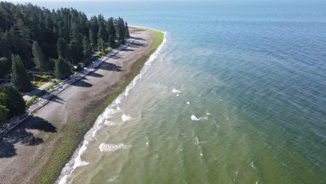 Aerial-fly-over-footage-of-Bonniebrook-beach-in-Gibsons,-British-Columbia-on-a-sunny-morning