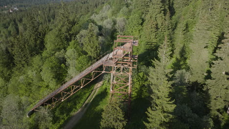 View-Of-Old-Rusted-Ski-Jump-Surrounded-By-Dense-Forest-In-Bakuriani,-Georgia