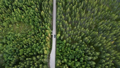 Overhead-View-Of-An-Isolated-Vehicle-Running-In-Forested-Country-Road-At-Dalarna,-Sweden